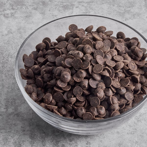 A glass bowl filled with unsweetened carob baking chips.