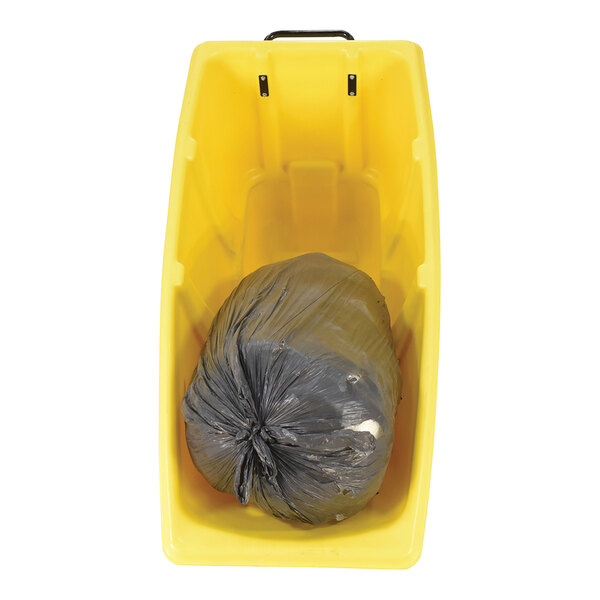 A yellow medium-duty bulk tilt truck containing a black trash bag.