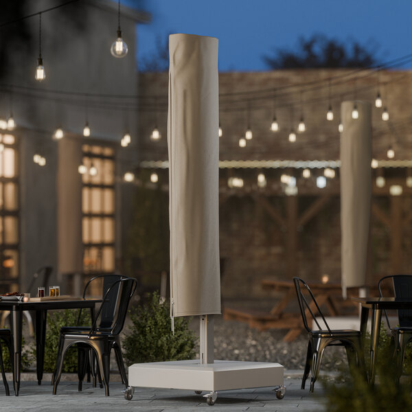 A beige polyester cantilever umbrella cover on a stand in an outdoor patio setting.