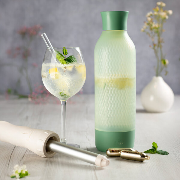 A sage green iSi Twist'N Sparkle Virtuoso 1 liter sparkling beverage system with a matching bottle and accessories.