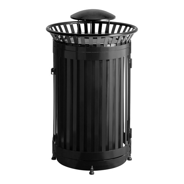 A large round black steel slatted outdoor trash can with a rain bonnet lid and door.