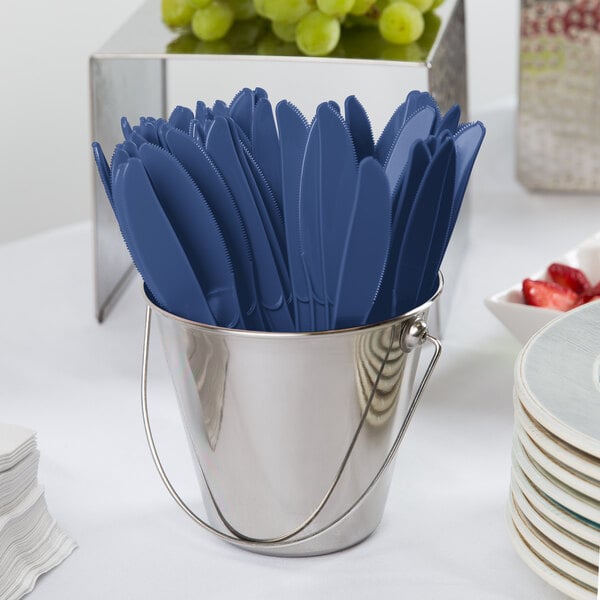 A small metal bucket filled with navy blue heavy weight plastic knives.