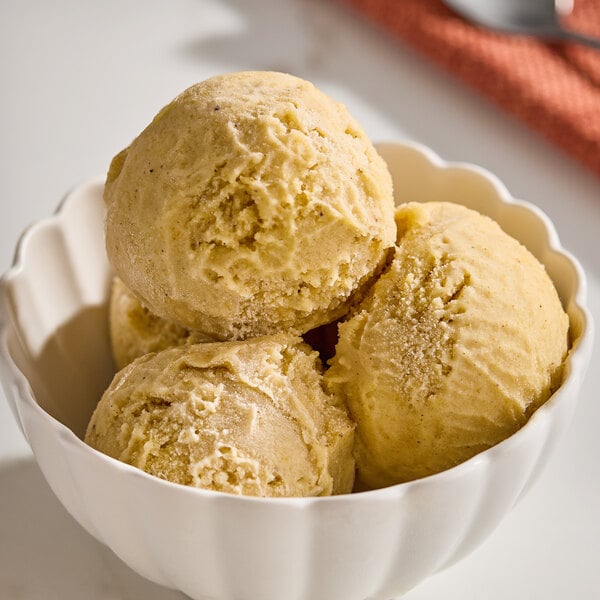 A white bowl filled with several scoops of pumpkin spice cream sorbet.