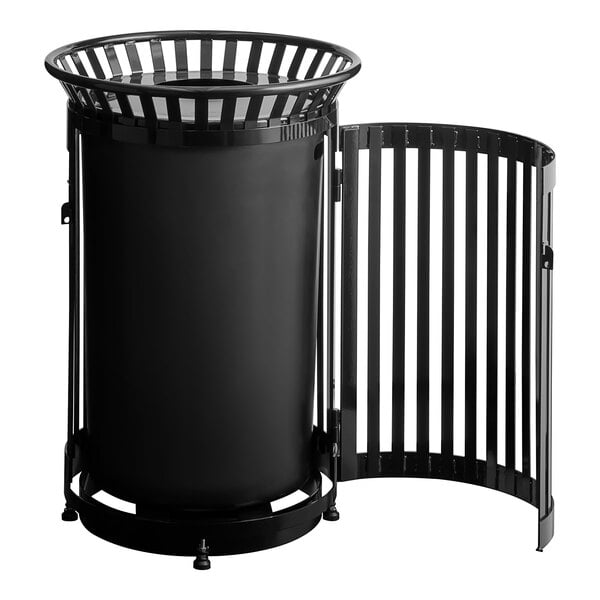 A large round black steel slatted outdoor trash can with a flat lid and a side door.
