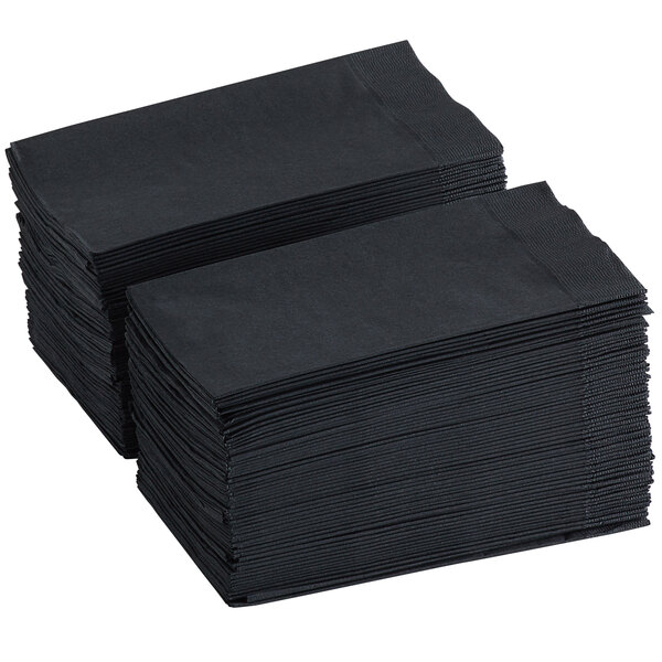 A stack of black 2-ply paper dinner napkins folded in a 1/8 style.