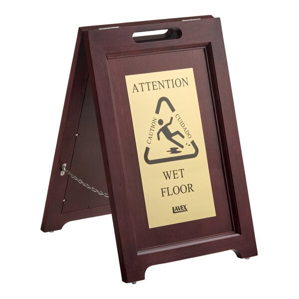 A wooden A-frame wet floor sign with brass-coated stainless steel plates.