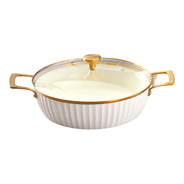 A white round induction-ready casserole pan with gold handles and a glass lid.