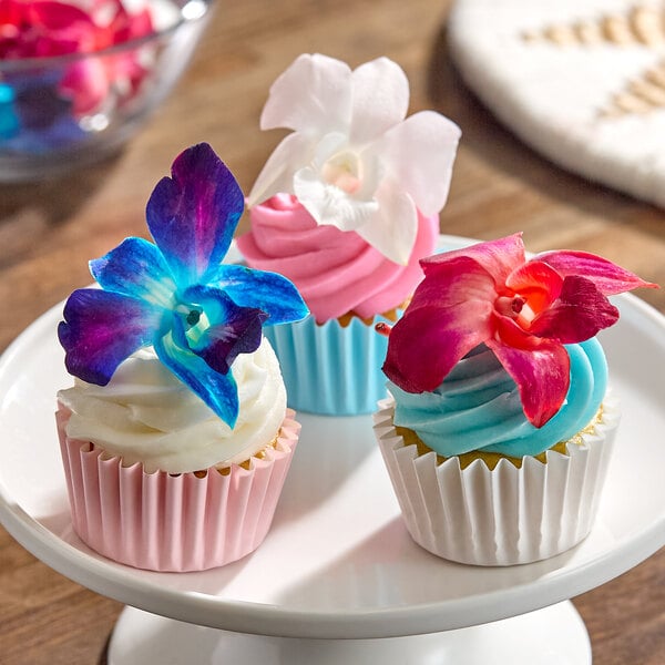 A set of cupcakes decorated with colorful edible orchid flowers from the Fresh Origins Patriotic Mix.