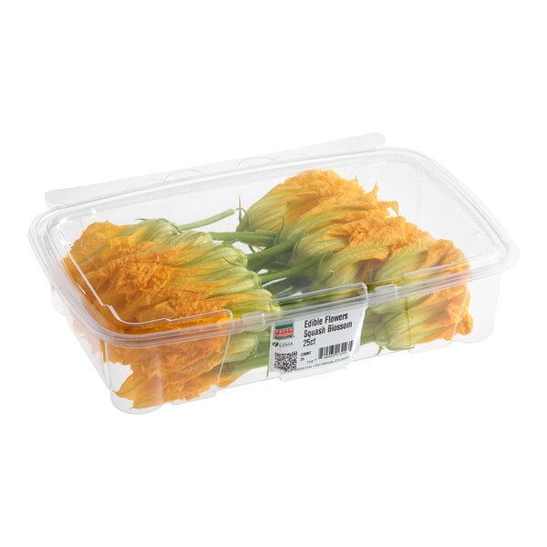 A clear plastic container filled with fresh squash blossom edible flowers.