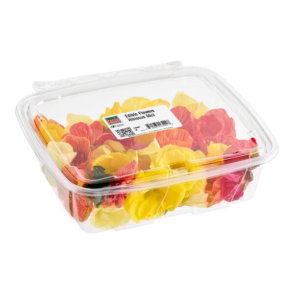 A clear plastic container filled with assorted colorful hibiscus edible flowers.