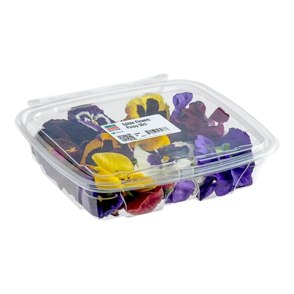 A clear plastic container filled with assorted colorful pansy edible flowers.