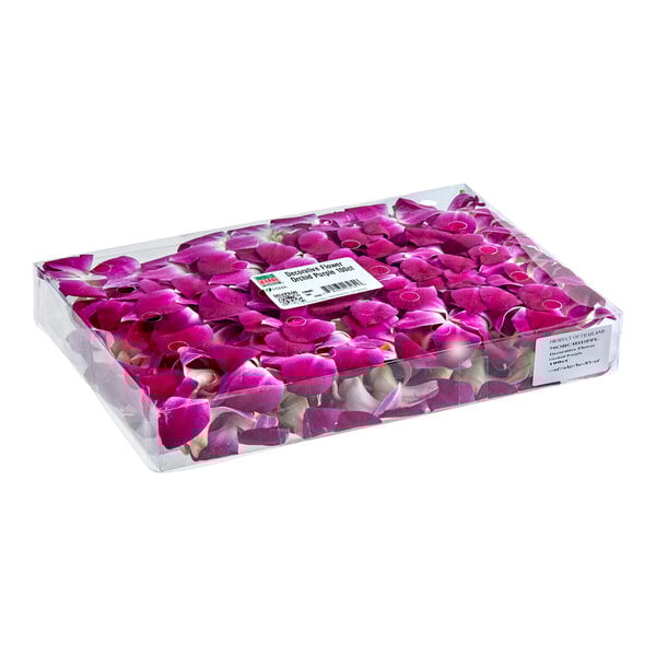 A clear plastic box containing 100 fresh purple edible orchid flowers.