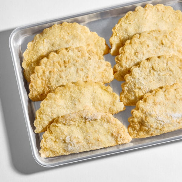 A tray of baked beef and cheese empanadas with a golden, flaky crust.