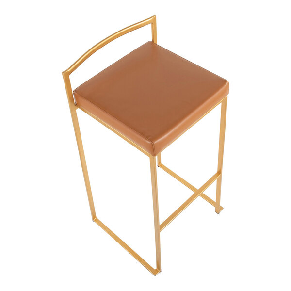 A gold steel barstool with a low back and a camel faux leather seat.