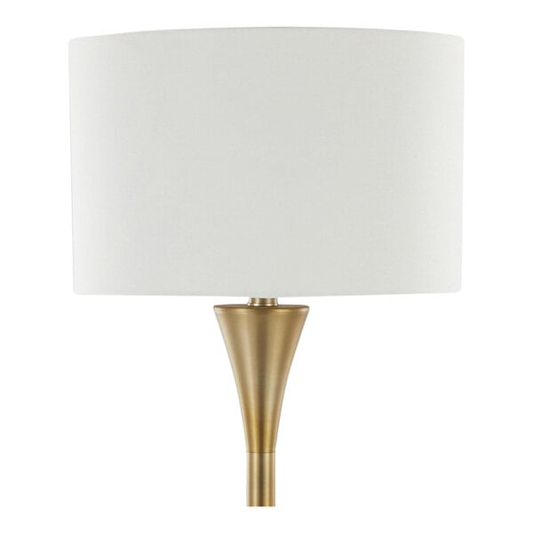 A gold metal floor lamp with a white linen drum shade.