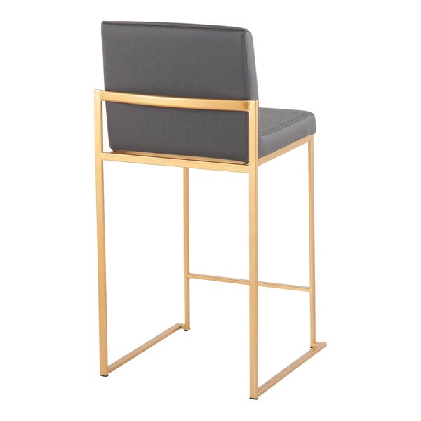 A modern counter height stool with a gold steel frame and gray faux leather back and seat.