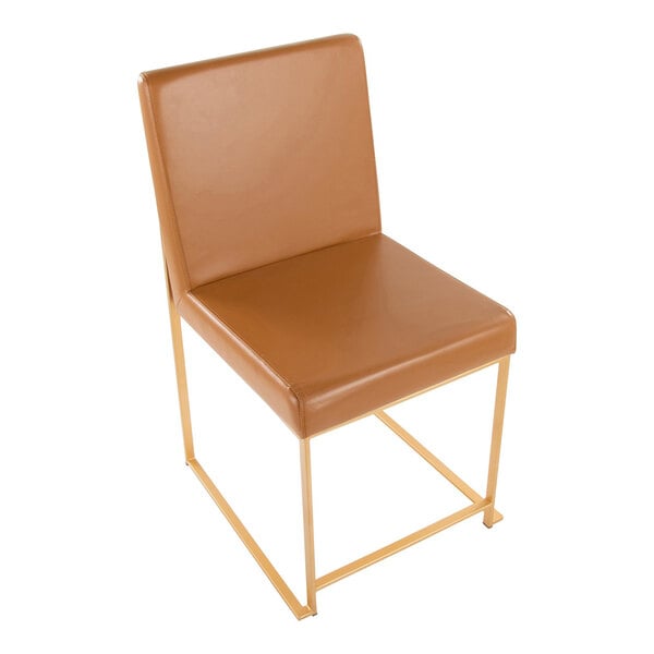 A modern side chair with camel-colored faux leather upholstery and a gold metal frame.