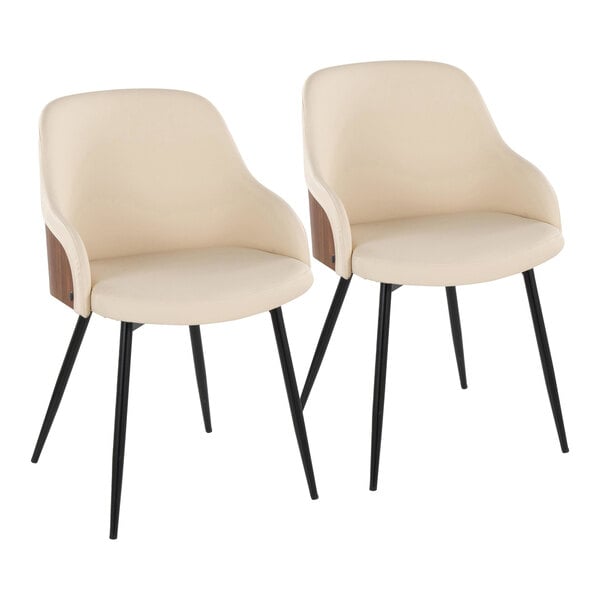 A pair of cream faux leather arm chairs with walnut wood accents and black metal legs.