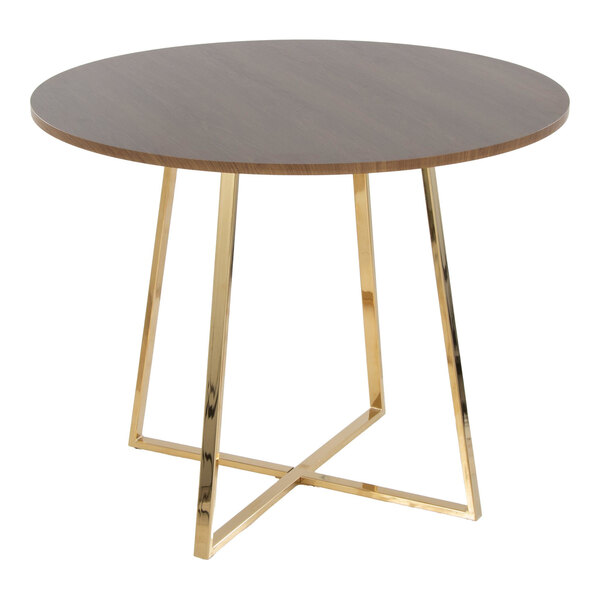 A round walnut wood dining table with a gold metal base.