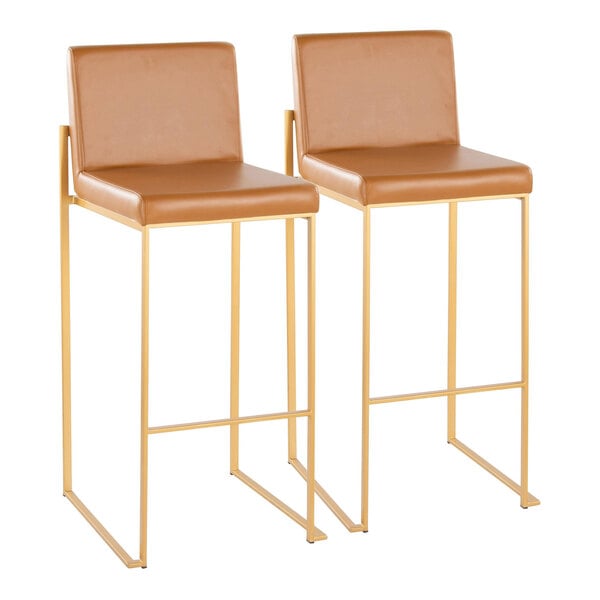 A pair of high back barstools with gold metal frames and camel faux leather seats and backs.