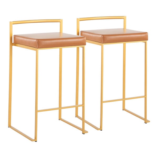 A pair of gold steel counter height stools with low backs and camel faux leather seats.