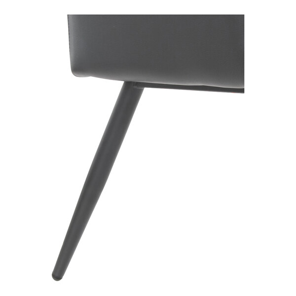 A close-up view of a black steel leg and part of the seat of a bench with black faux leather upholstery.
