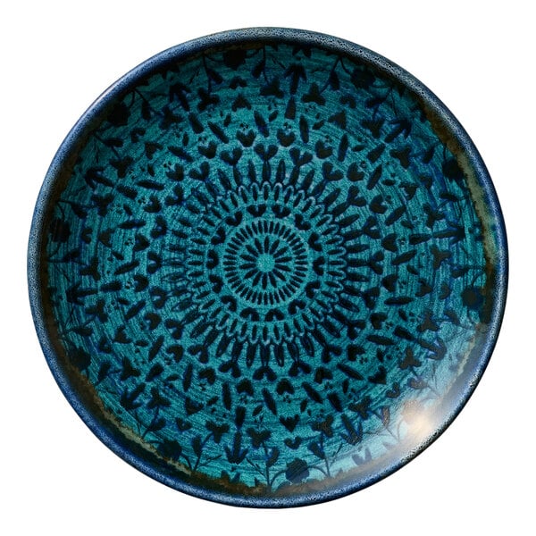 A round blue porcelain coupe plate with a decorative pattern.