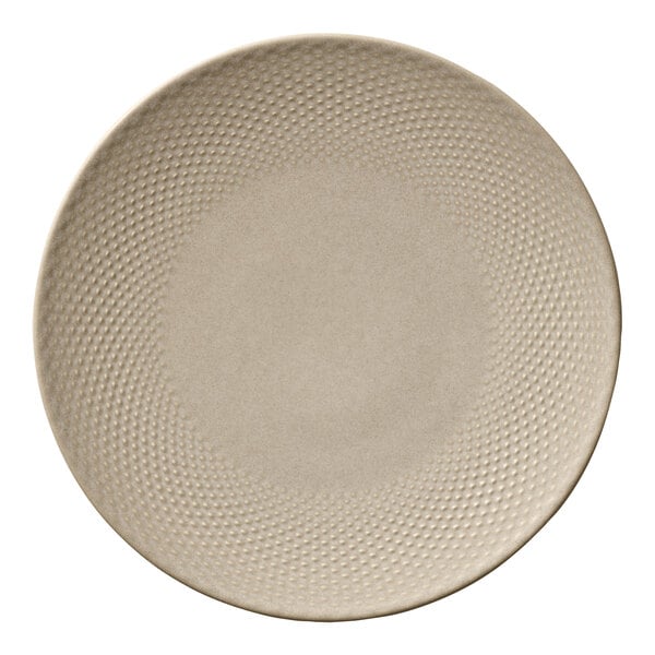 A round almond-colored porcelain coupe plate with a textured rim.
