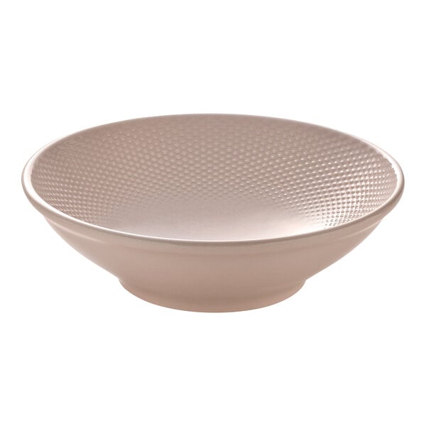 A round blush-colored porcelain bowl with a textured interior.