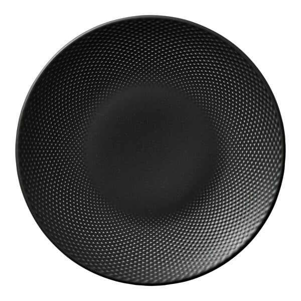 A round black porcelain coupe plate with a textured pattern.