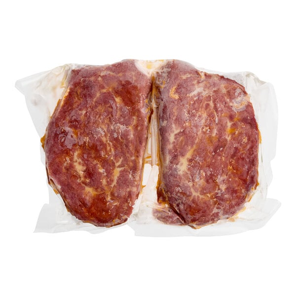 A vacuum-sealed package containing two plant-based filet mignon steaks.