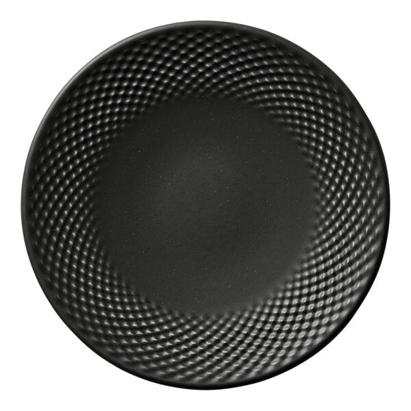 A round black porcelain coupe plate with a textured pattern around the rim.
