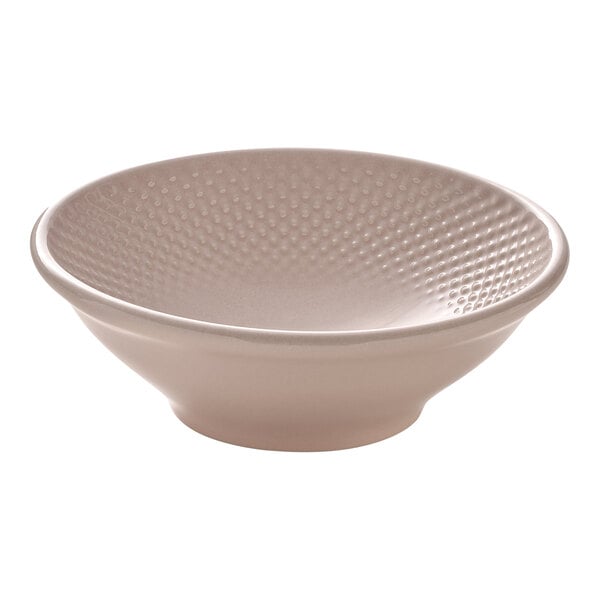 A round blush porcelain bowl with a textured interior.