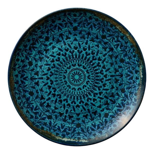 A round blue porcelain coupe plate with an intricate patterned design.