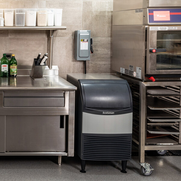 A Scotsman undercounter air-cooled ice machine with a built-in bin, situated in a commercial kitchen setting.