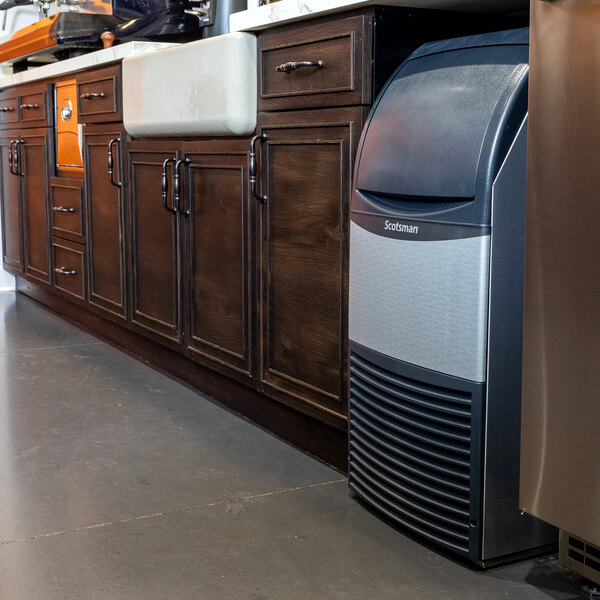 A Scotsman undercounter air-cooled ice machine with a stainless steel finish and a built-in storage bin.