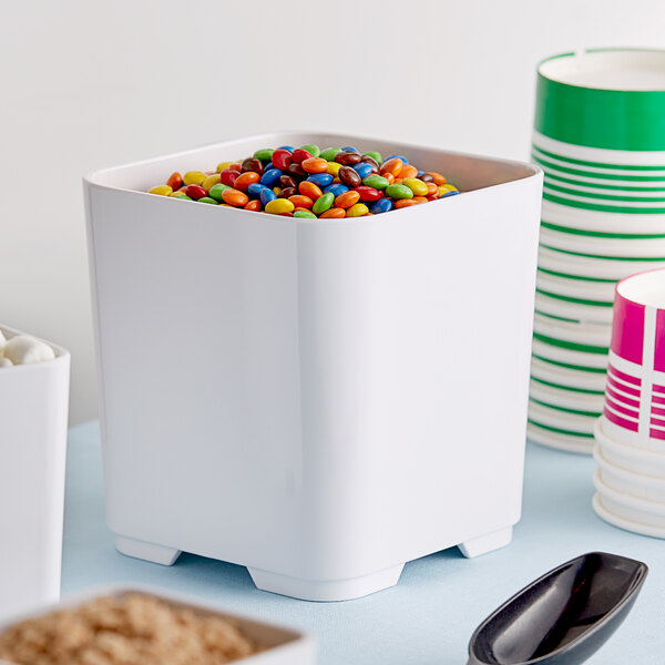 A square white melamine jar filled with colorful candy.