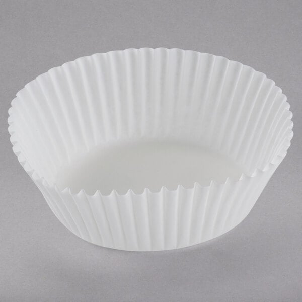 A close up of a white fluted paper cupcake liner.