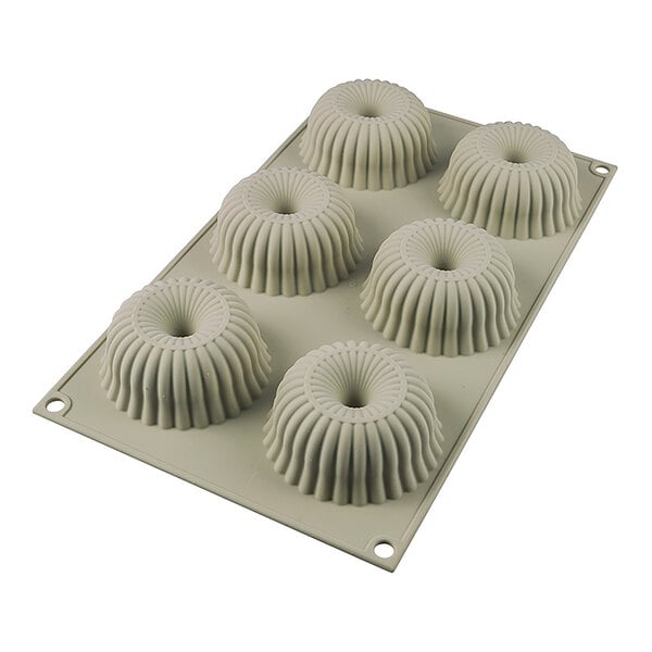 A silicone baking mold with six ridged donut-shaped cavities.