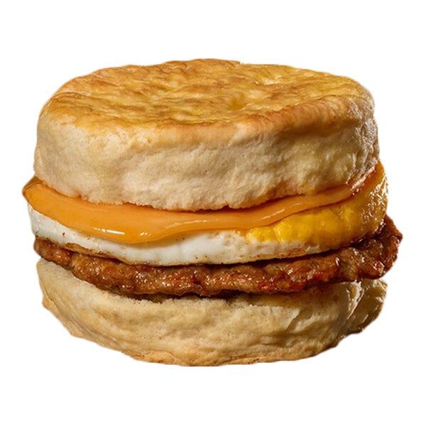 A breakfast sandwich with a biscuit, sausage patty, egg, and cheddar cheese.