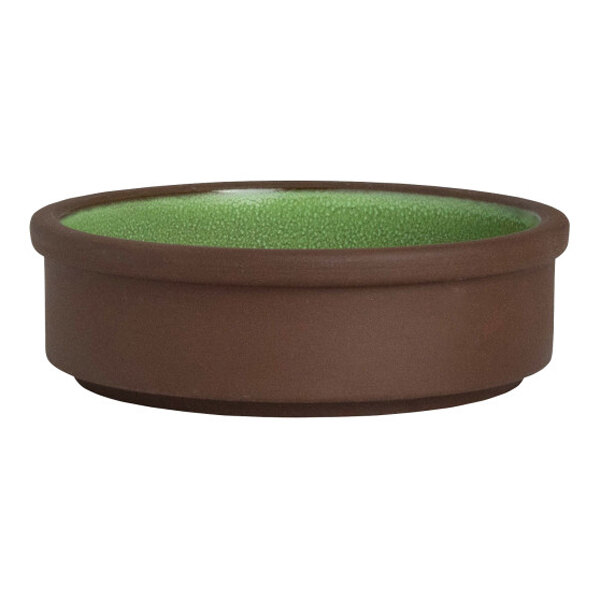A round, brown stoneware tray with a green interior, designed to be stackable and deep, measuring 4 inches in diameter.