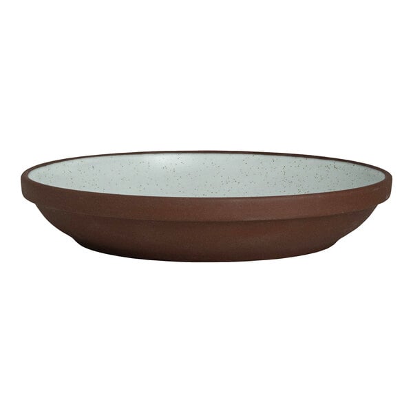 A round, deep stoneware plate with a brown exterior and a speckled light interior.