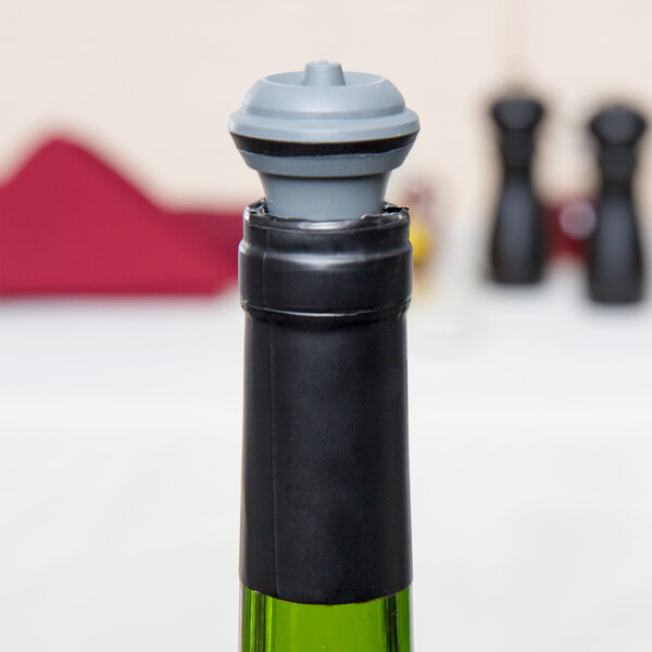A gray Vacu Vin replacement wine stopper fitted on the neck of a wine bottle.
