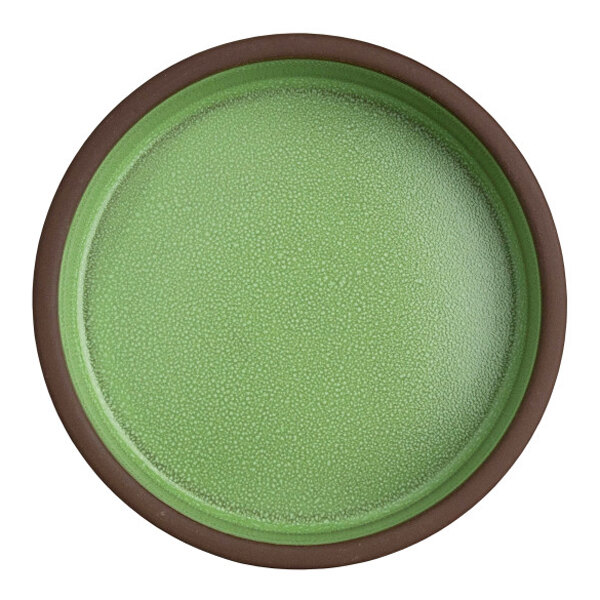 A round, green stoneware deep tray with a brown rim.