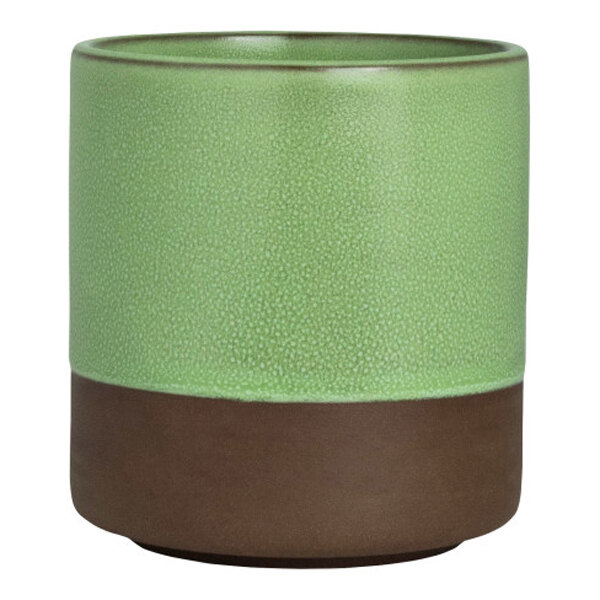 A round stoneware cup with a green upper section and a brown base.