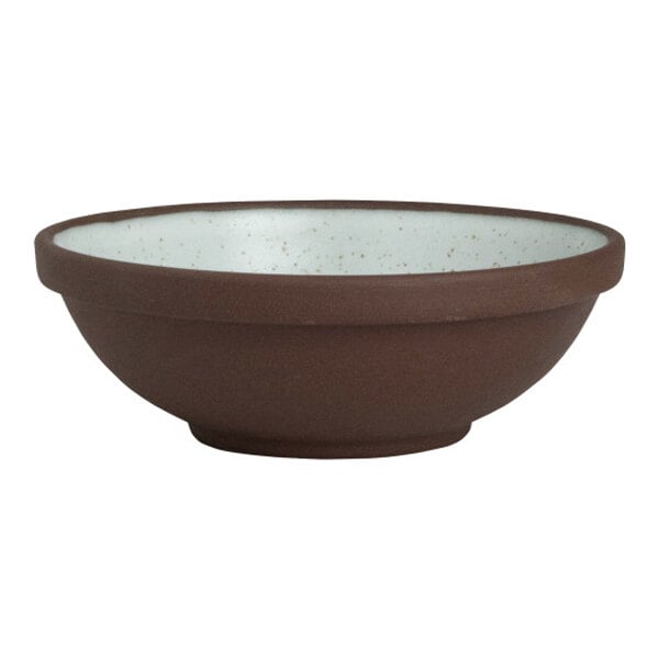 A round stoneware ramekin with a brown exterior and a speckled white interior.