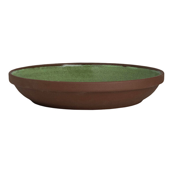 A round, deep stoneware plate with a brown exterior and a green interior.