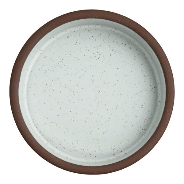 A round, speckled white stoneware tray with a brown rim.
