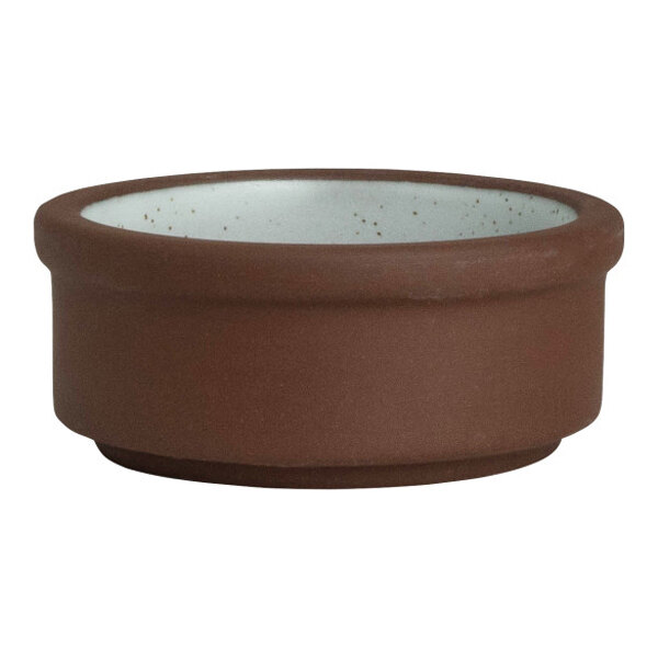 A small, round, brown and white stoneware tray designed for holding spices or condiments.