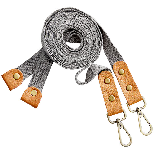 A pair of gray cross-back replacement straps with tan leather accents and metal clips.